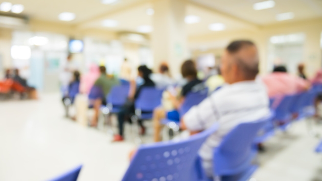 a group of patients, including men and women, sit in a waiting room in a hospital. 